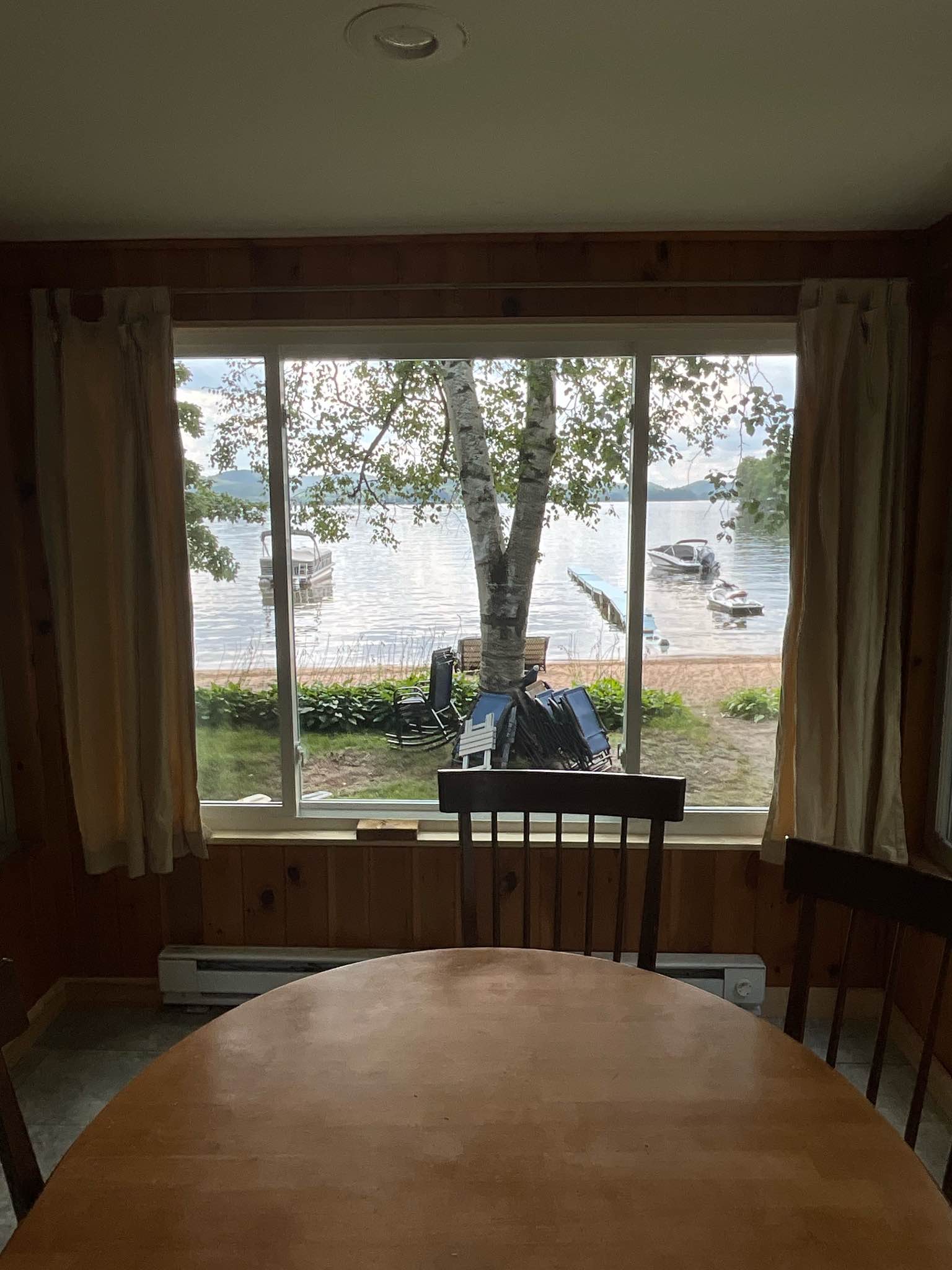 Interior view toward the lake after the project, with a wide unbroken sightline to the shoreline and docks